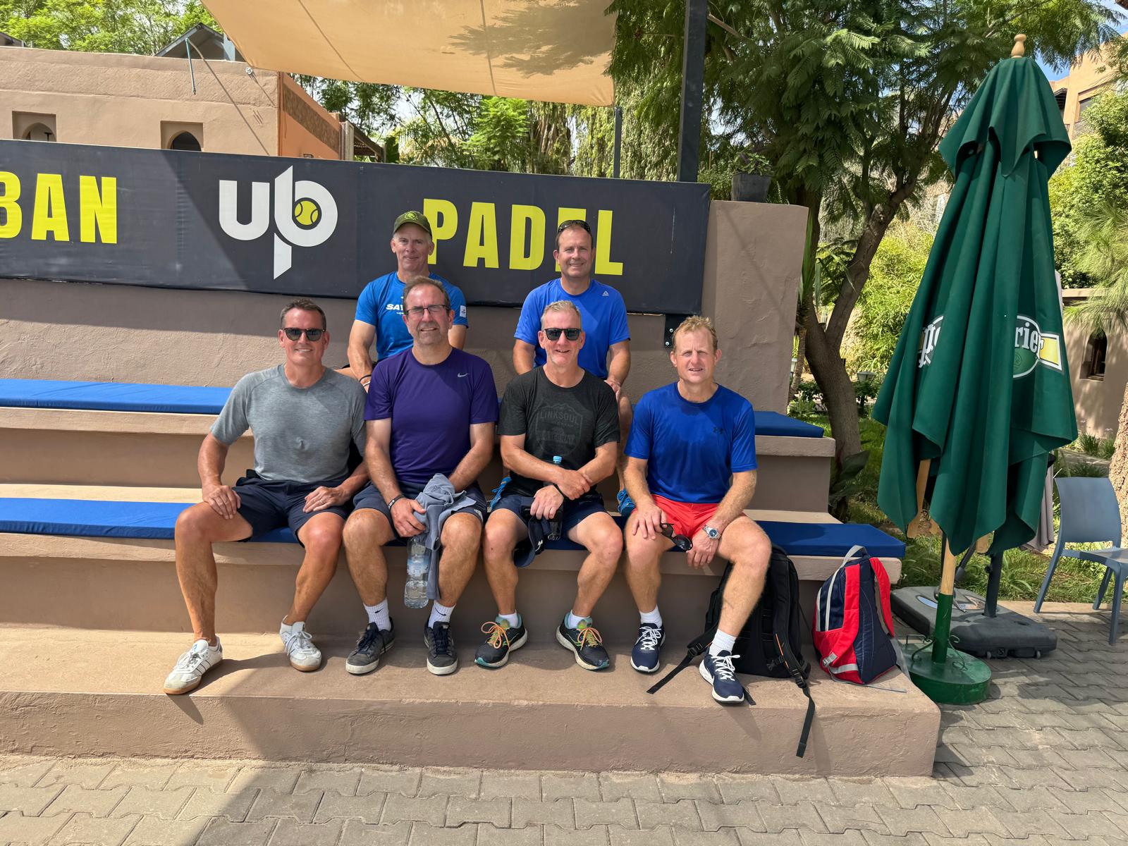 Four Reloaders resting beside the padel court