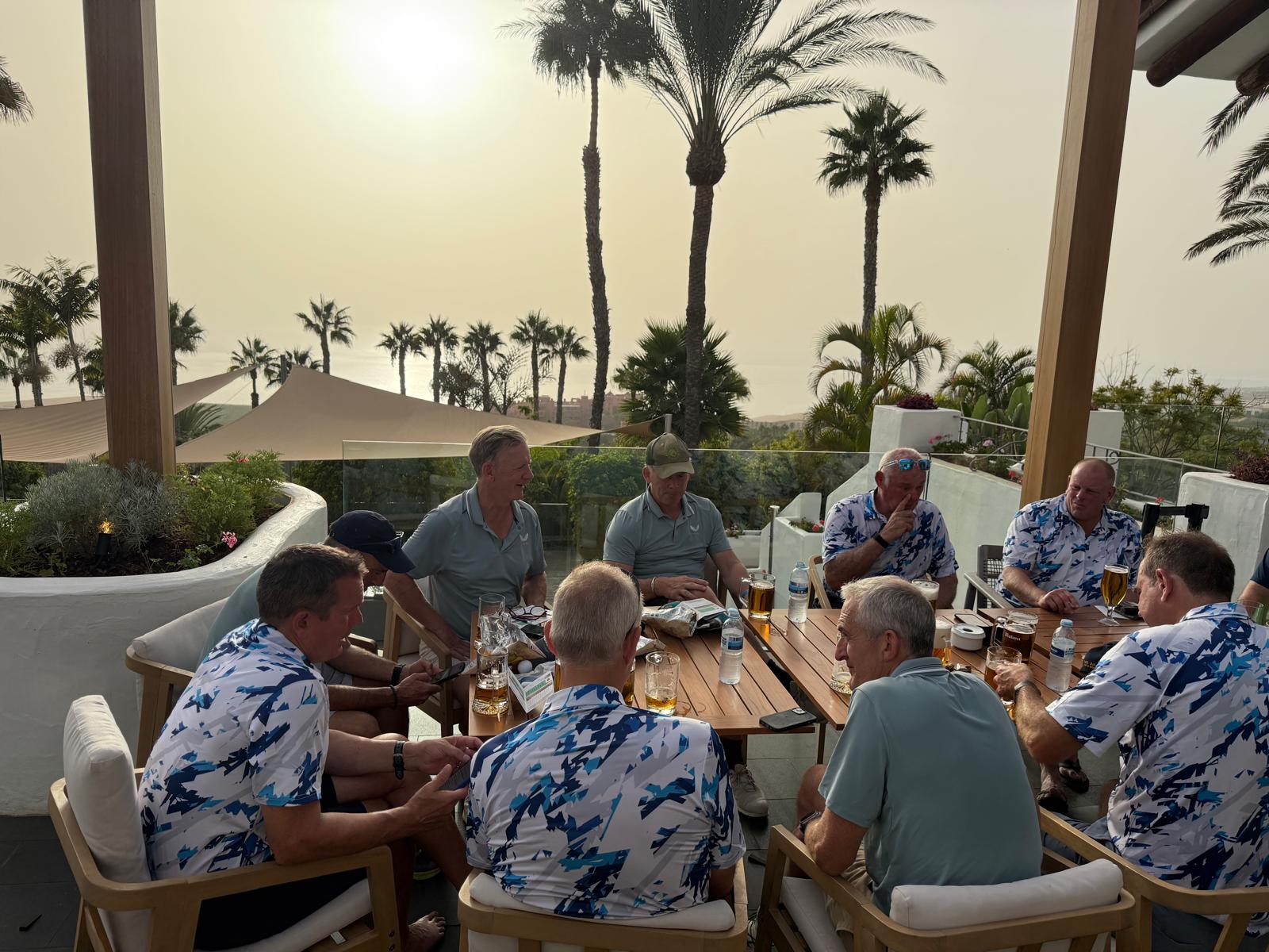 The group seated at a terrace table